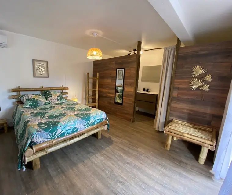 Ti Bambou — La chambre, lit en bambou et parure tropicale